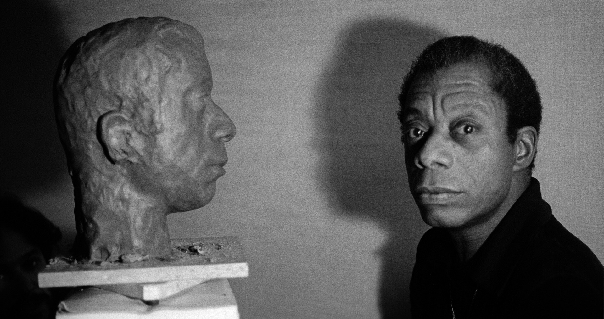 A photo by Jane Evelyn Atwood	, titled James Baldwin with bust of himself sculpted by Larry Wolhandler, Paris, France, dated 1975.